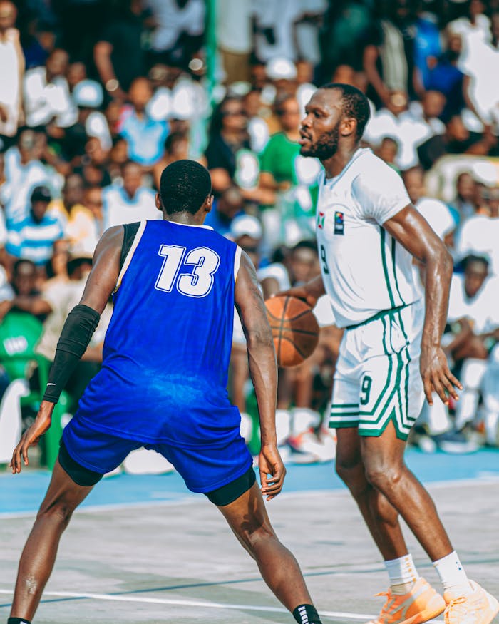 Two basketball players competing outdoors during a vibrant game day.