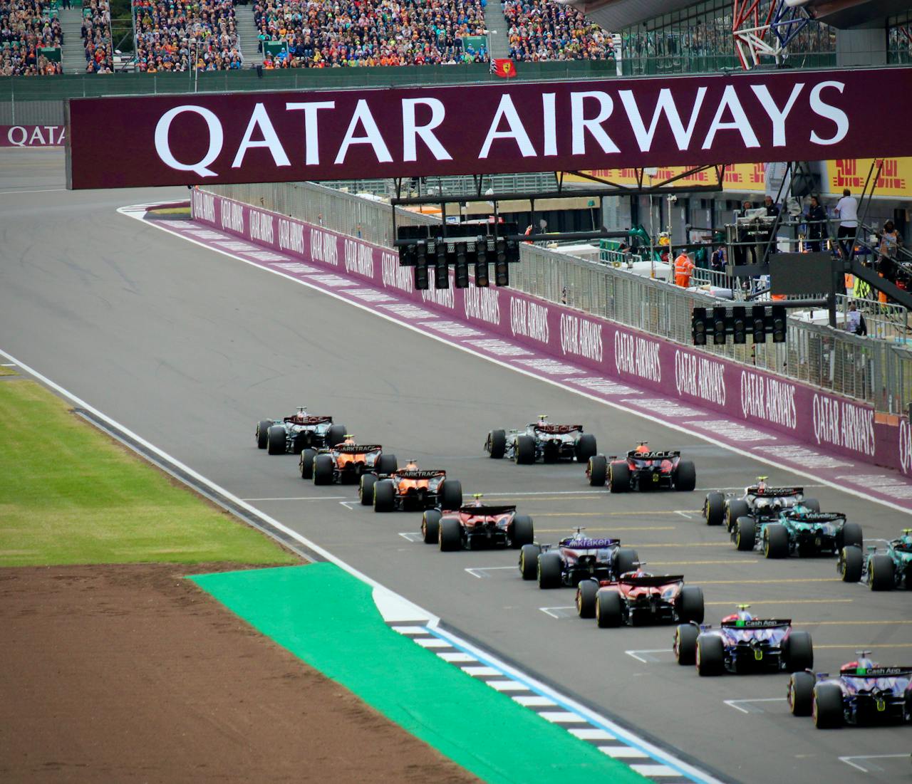 High-speed Formula 1 cars line up on the Silverstone Circuit, ready for an adrenaline-pumping race.
